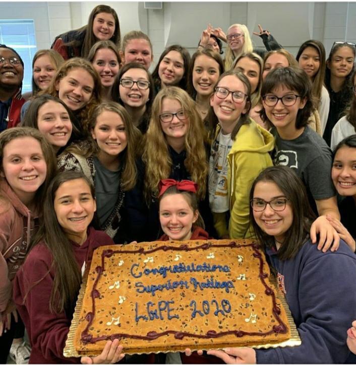 The Advanced Women's Chorus celebrating their superior ratings on their LGPE performances with a cookie cake