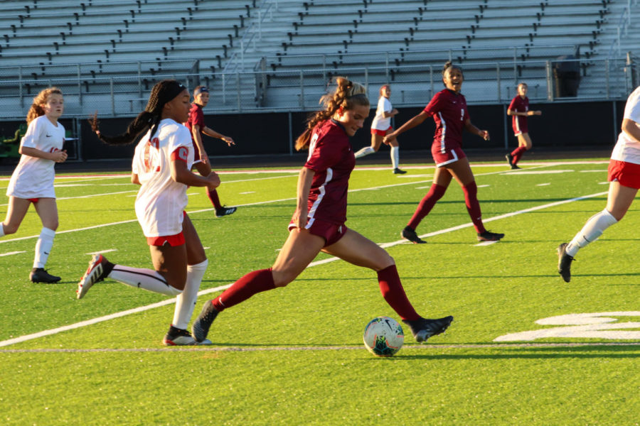 Mill Creek High Schools girls soccer team during their 2021 spring season. The bleachers are lacking in large numbers of spectators, and the players . . .