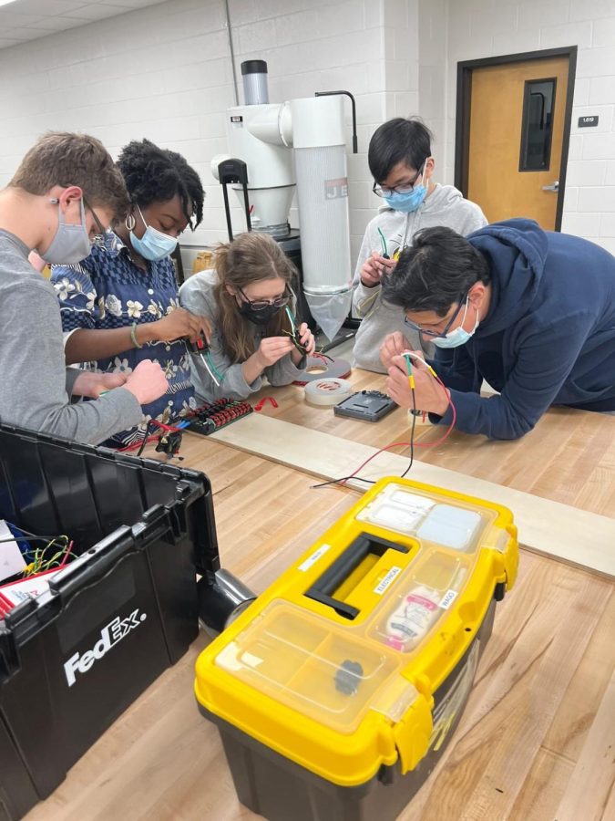 Steel Talon members focus as they work to build the drive base of their robot.