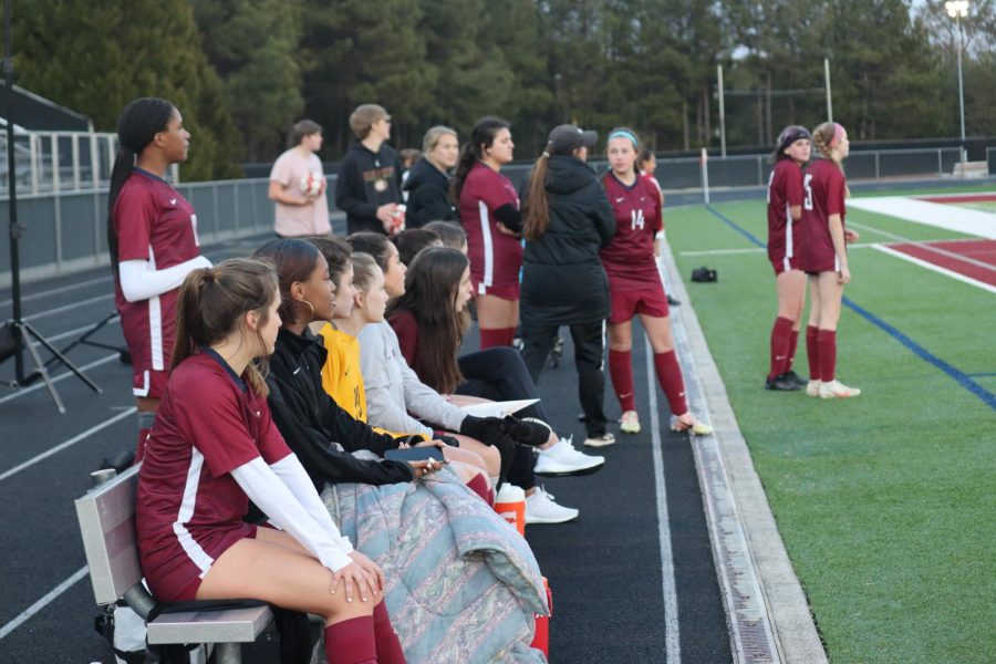 Jv girls huddled up on the bench during first game of the season.