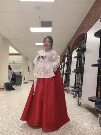 Phoebe Yoon, 11, smiles big for a picture in her traditional Korean Hanbok as she celebrates her culture at International Night.