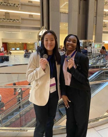 Allison Shin , 9 , posing with Zaina Davies , 10 , after DECA competition
