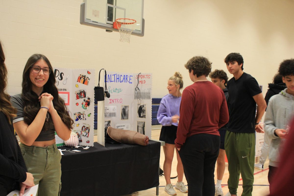 High school students are seen introducing the eighth graders to the Foods and Healthcare electives in the Auxillary Gym. 