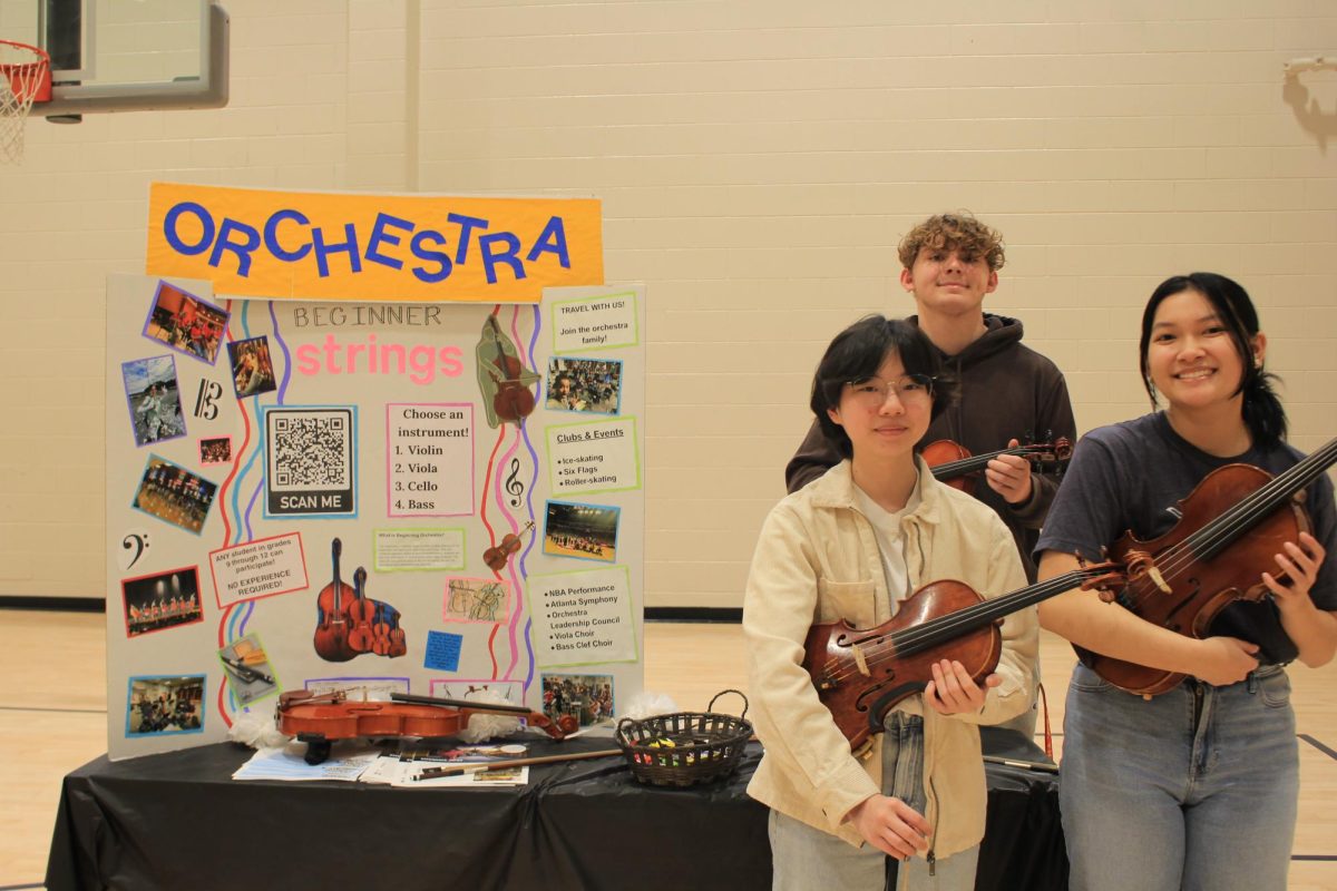 Andrew Petersen, 11, Vic Jeon, 12, and Chelsea Nguyen, 12, representing the orchestra elective at the eighth grade elective fair. 