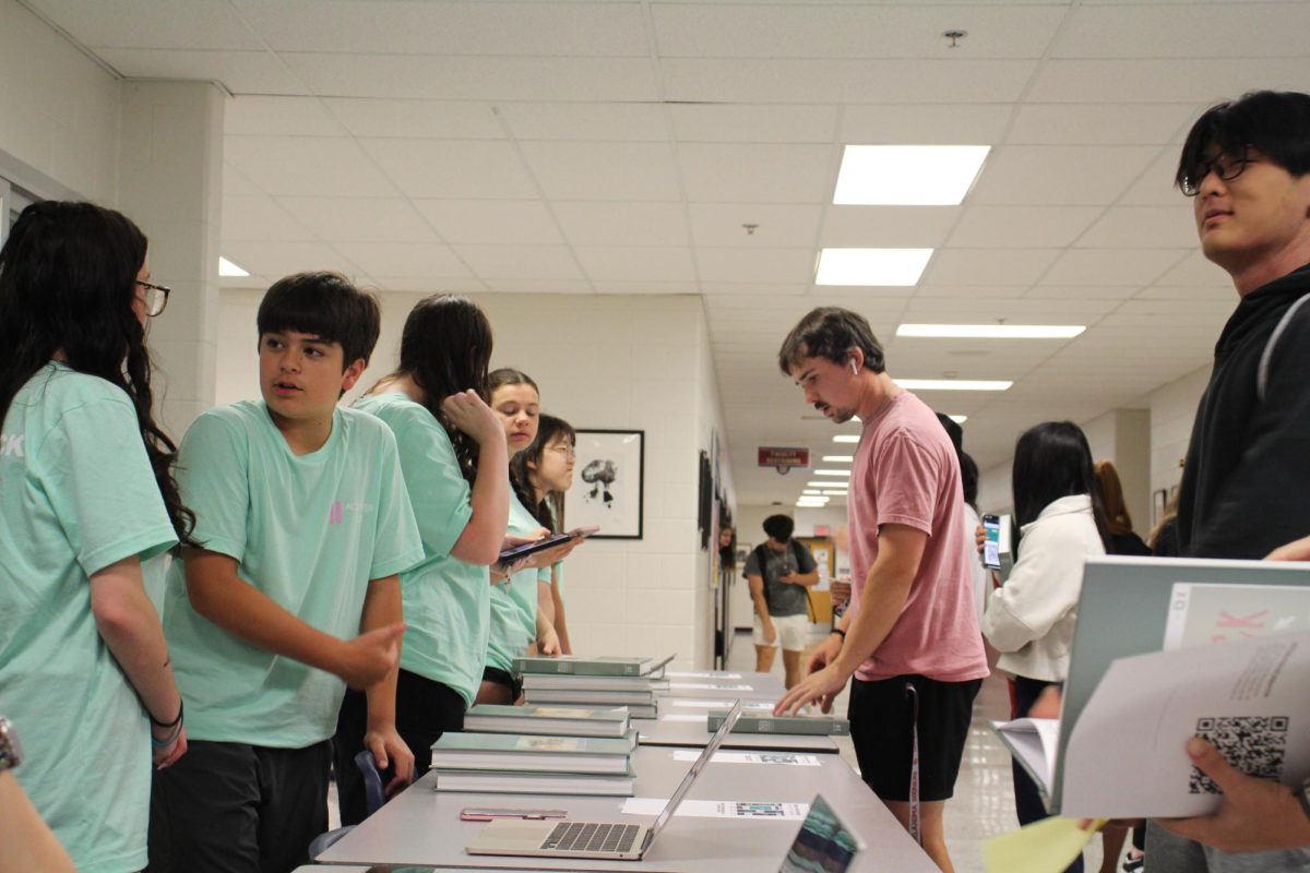 Yearbook staff handing out students yearbooks.