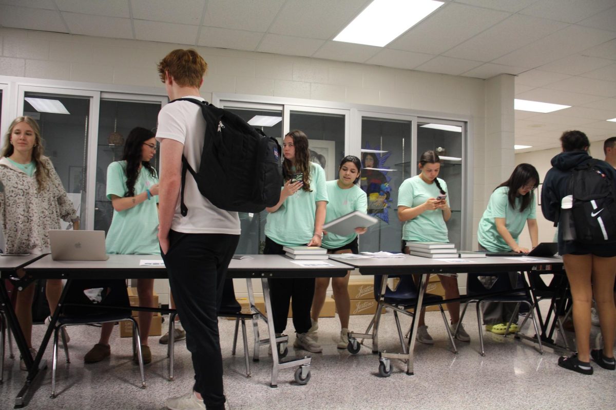 Yearbook staff during 4th period, handing out yearbooks to students leaving the lunch room.